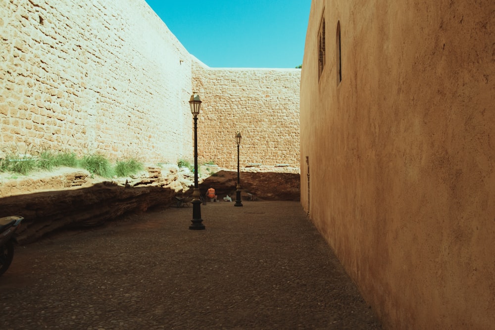 a narrow alley between two buildings with a lamp post