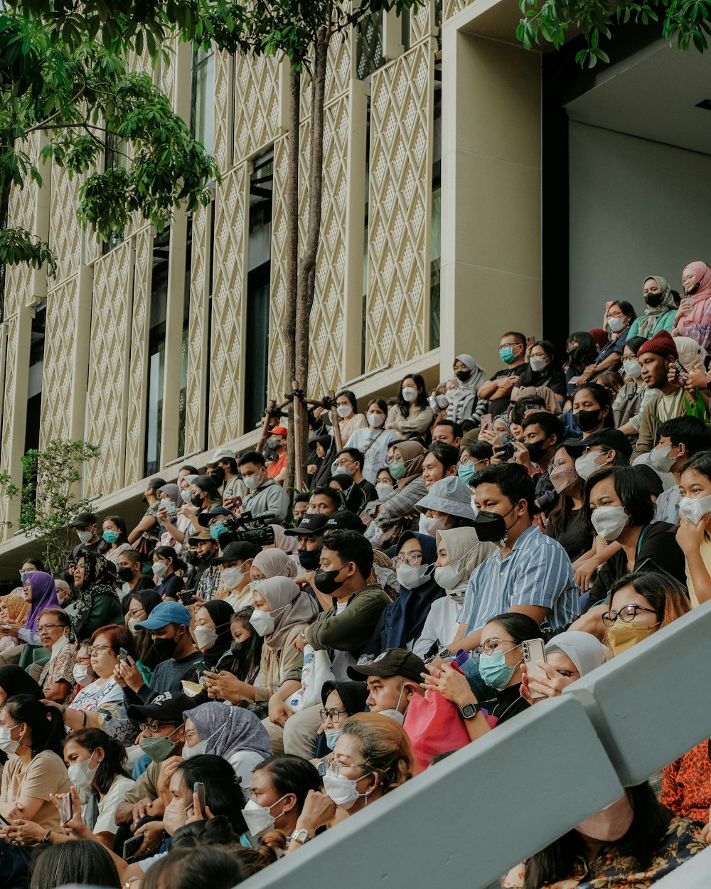 a crowd of people sitting on top of a bleachers