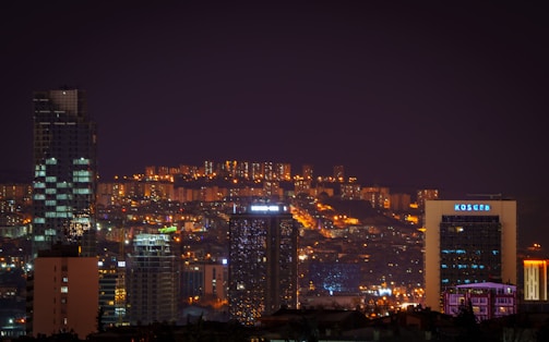 A cityscape at night, illuminated by the glow of streetlights.