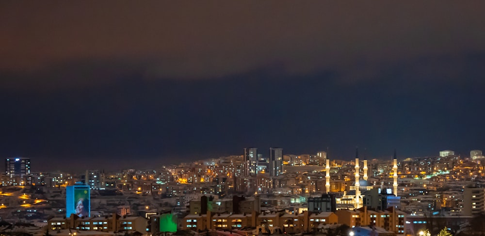 Una vista de una ciudad por la noche desde una colina