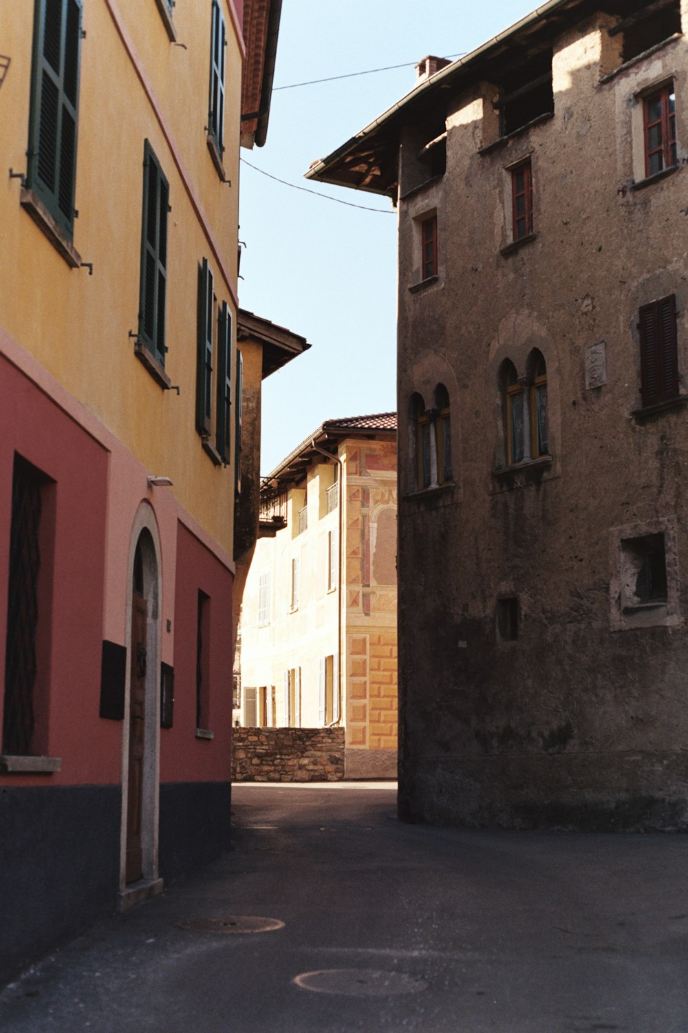 an alley way with a clock on the side of it