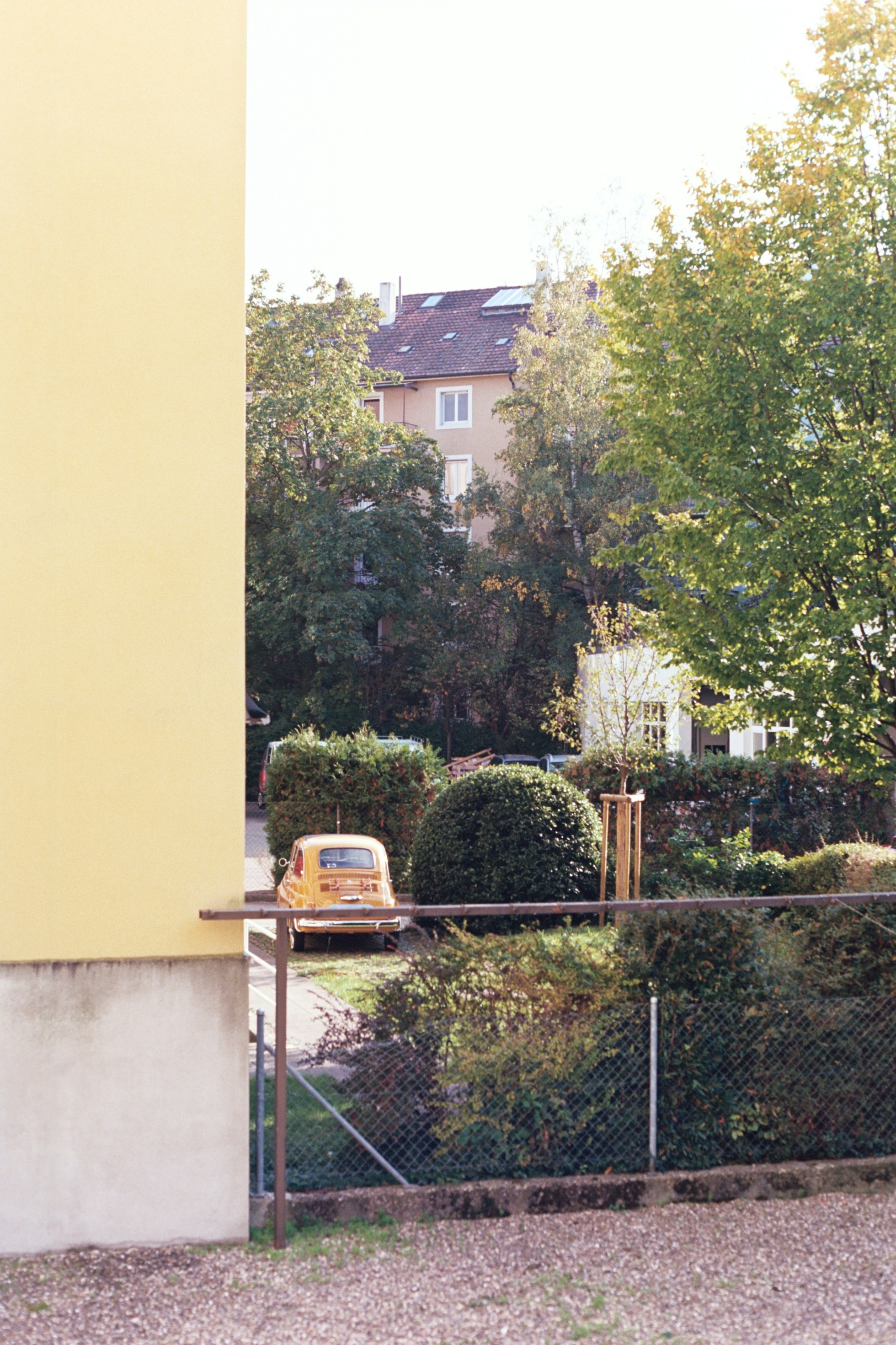 A yellow van parked in front of a tall building photo – Free Basel ...