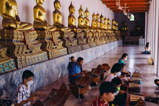 Children learning traditional arts and crafts in a bright, welcoming temple hall.