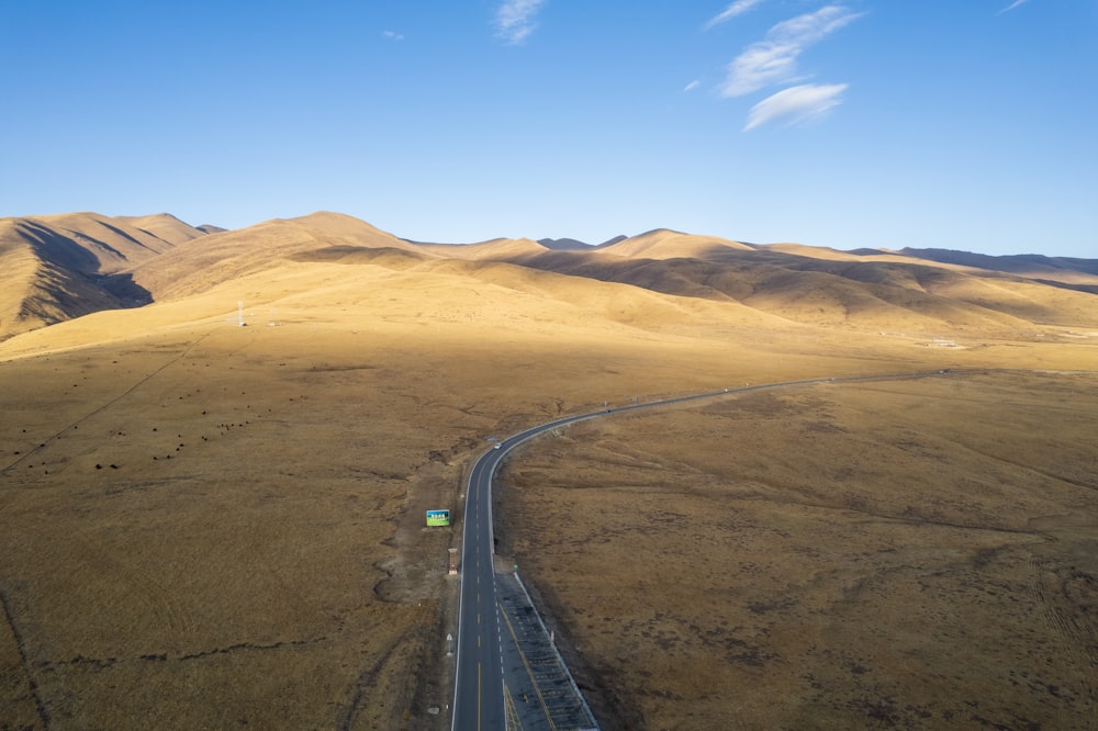 a truck driving down a road in the middle of a desert