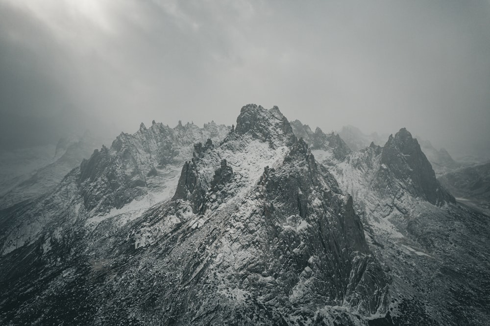 a mountain covered in snow under a cloudy sky