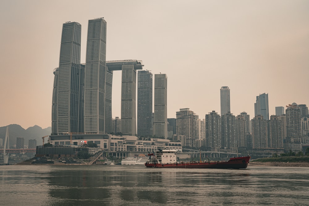 a large boat in a body of water near tall buildings