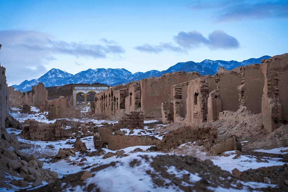 the ruins of a building in a desert with mountains in the background