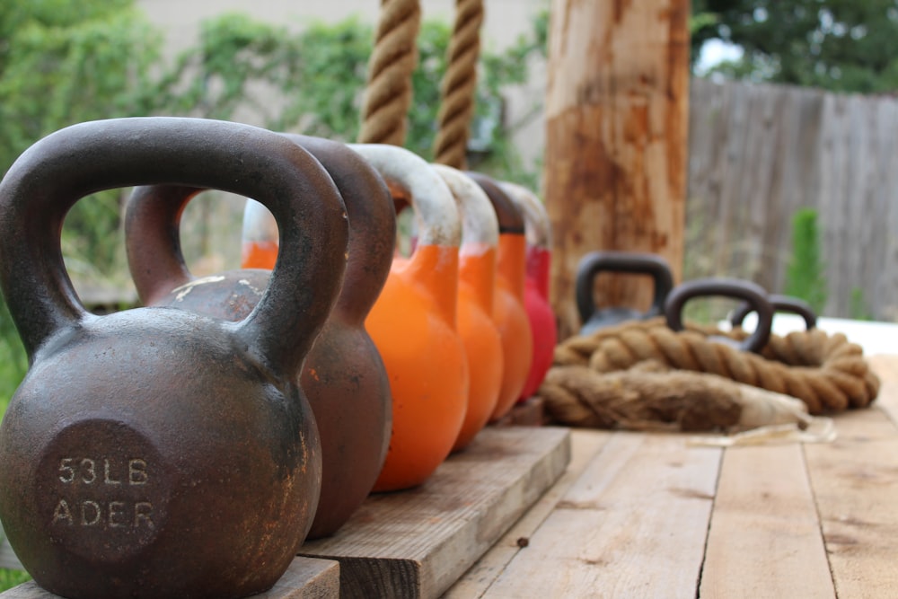 a row of kettles sitting on top of a wooden table