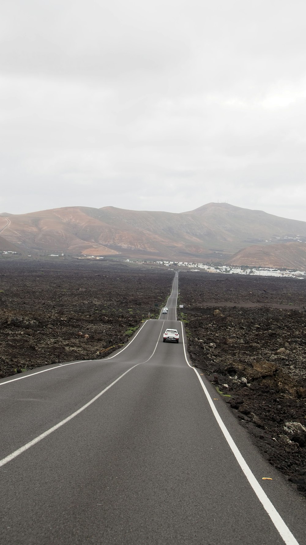 a car driving down a road in the middle of nowhere