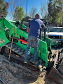 Technician using diagnostic equipment to check engine performance on a bulldozer at a construction site.