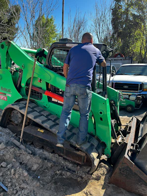 Technician using diagnostic equipment to check engine performance on a bulldozer at a construction site.