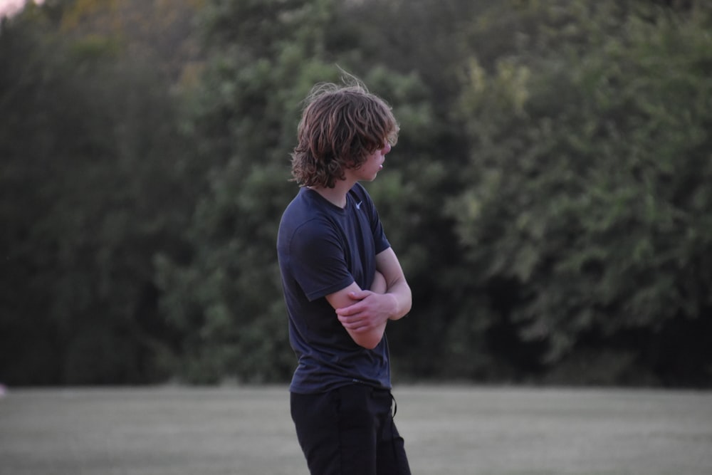 a man standing in a field holding a frisbee