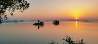 A serene sunrise over the lush, green hills of Namatoto island, with the calm sea reflecting the warm colors of dawn.