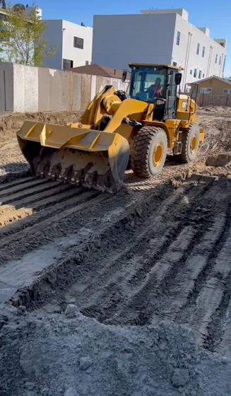 a large yellow bulldozer sitting on top of a dirt field