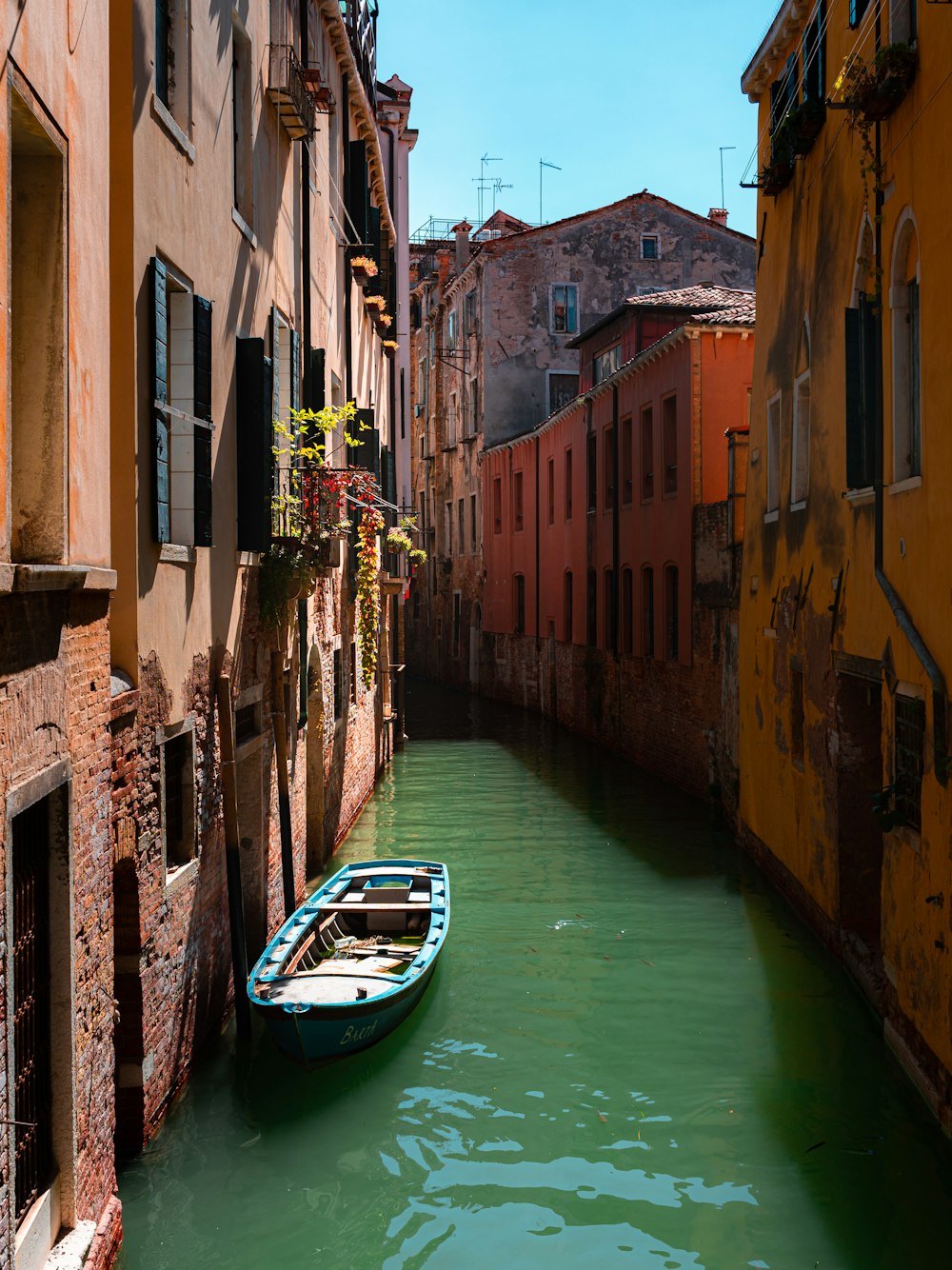 a small boat in a narrow canal between two buildings