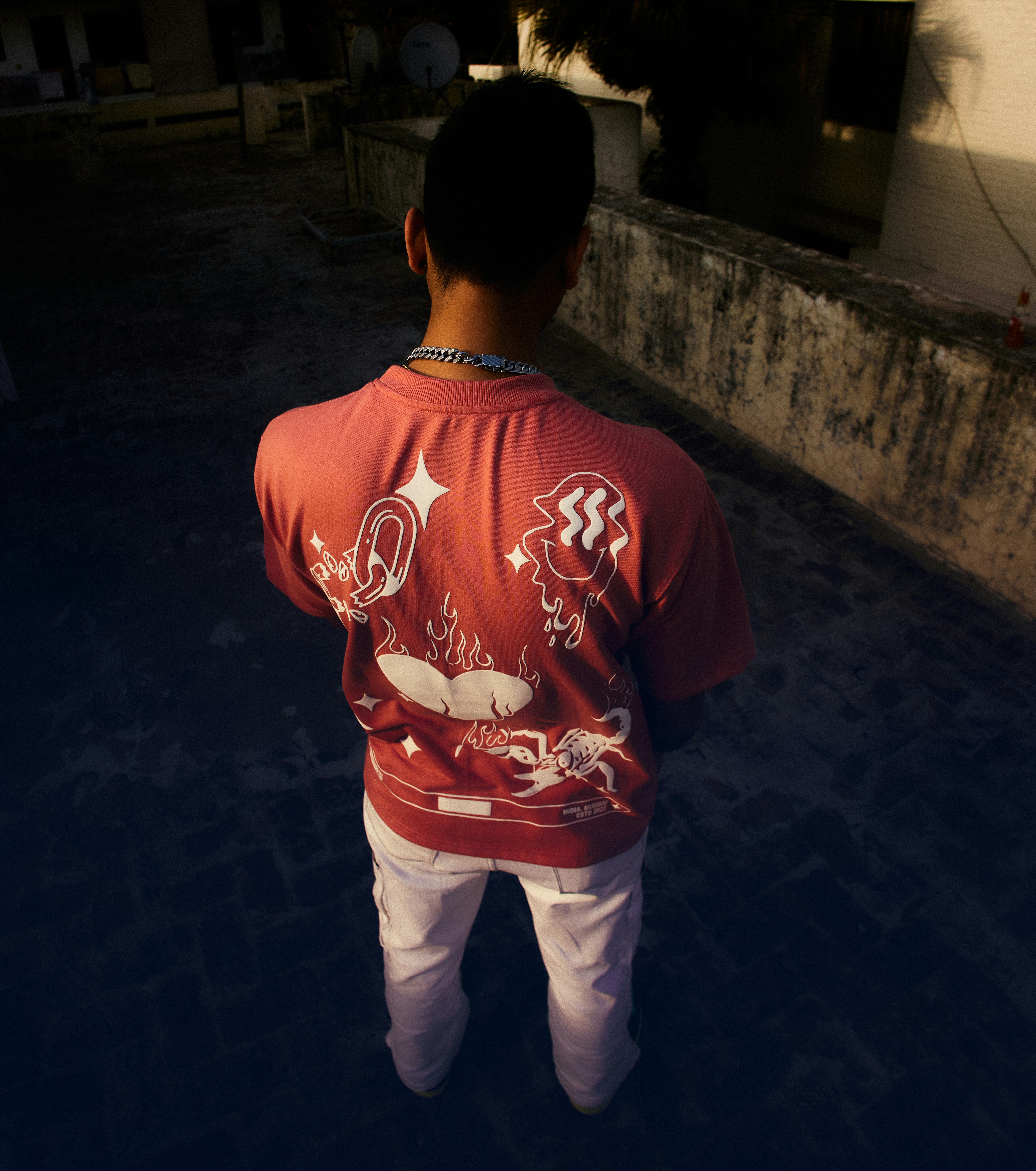 a young boy in a red shirt and white pants