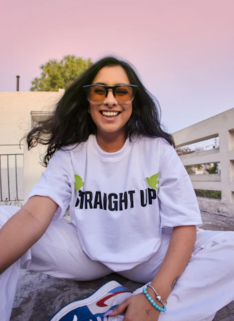 A happy customer wearing a custom noirvibe t-shirt, smiling outdoors on a sunny day.
