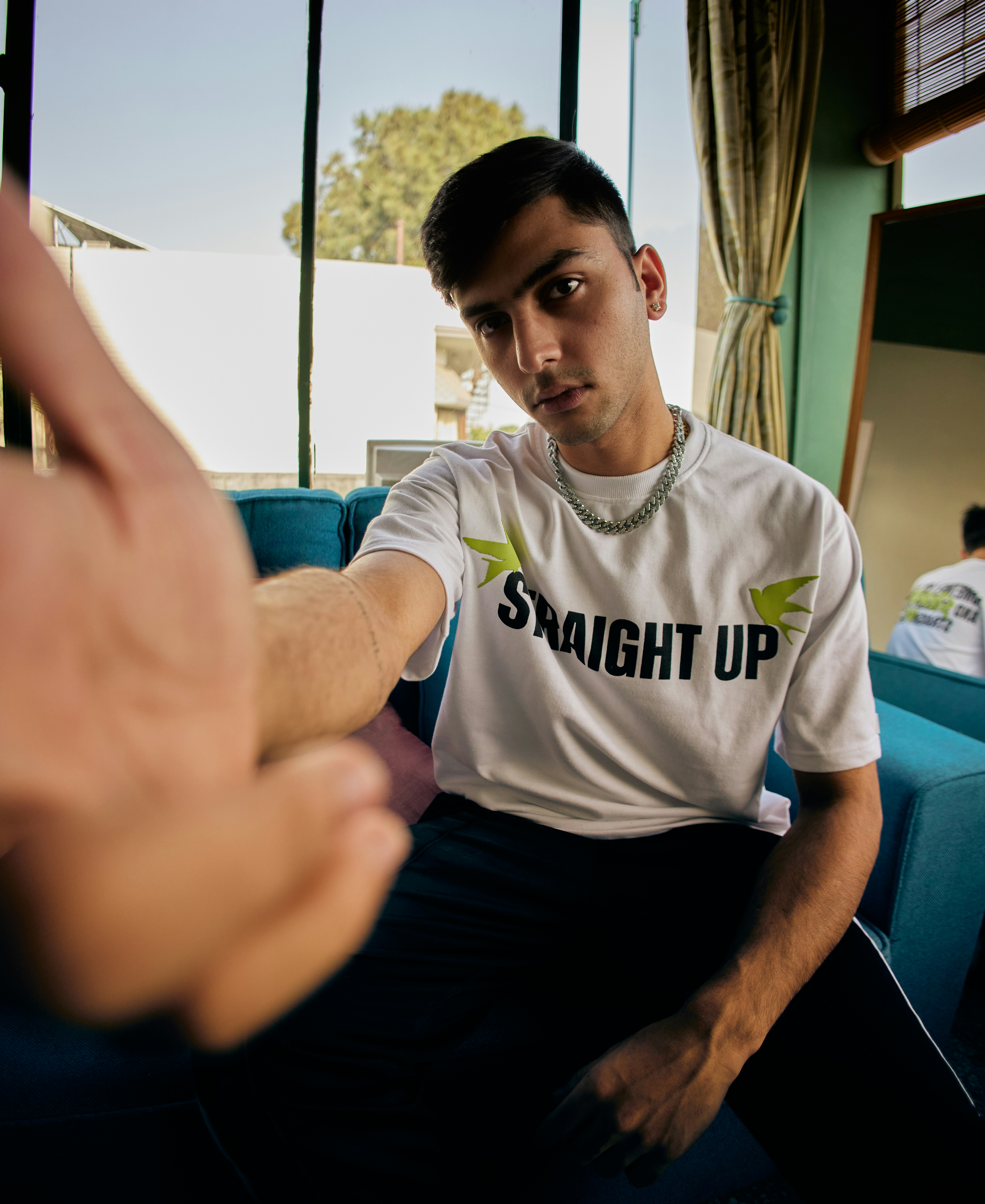 a man sitting on a couch pointing at someone