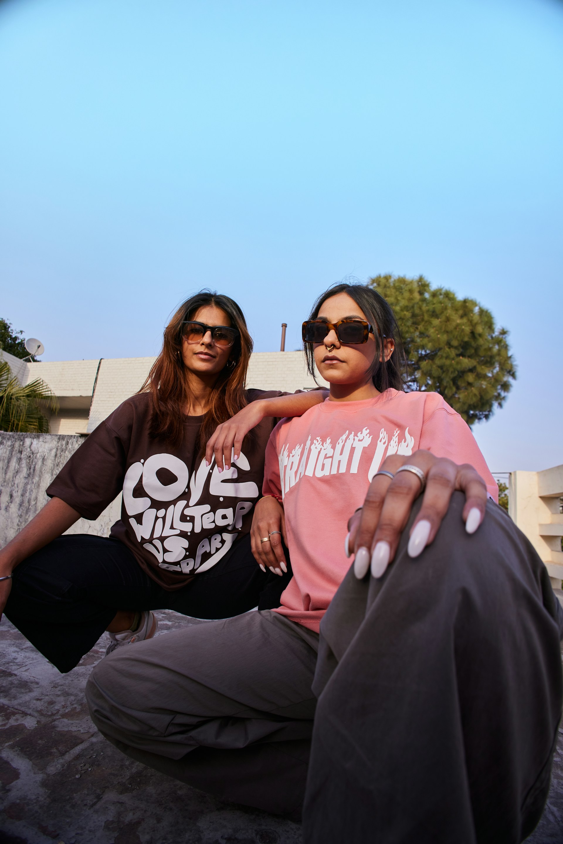 two women sitting on a rock with their arms around each other
