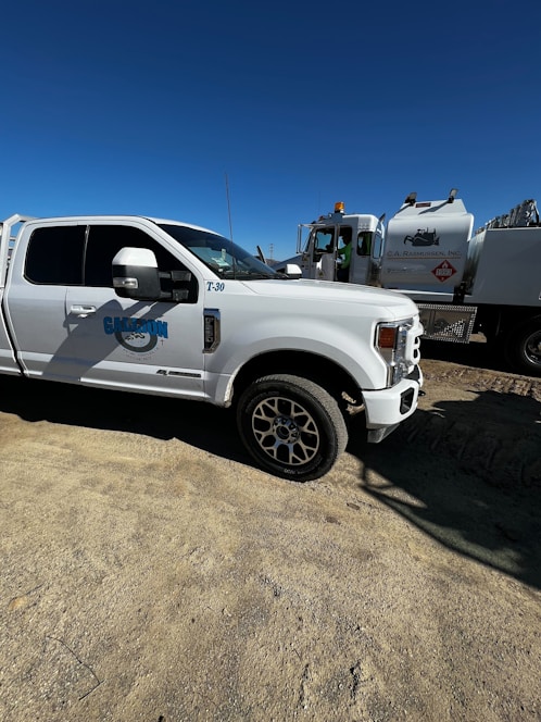 A water truck parked in a sunny urban environment, ready for service.