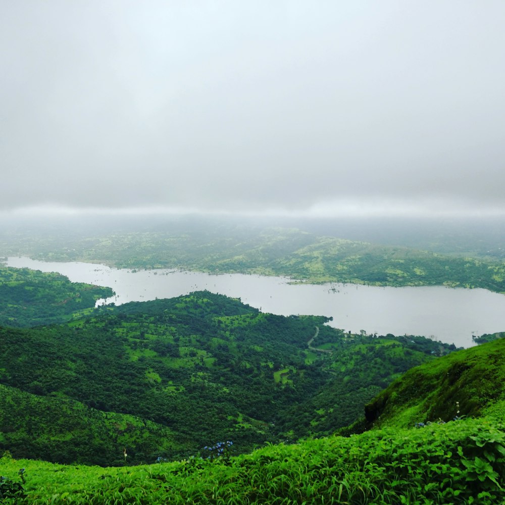 a view of a lake surrounded by lush green hills