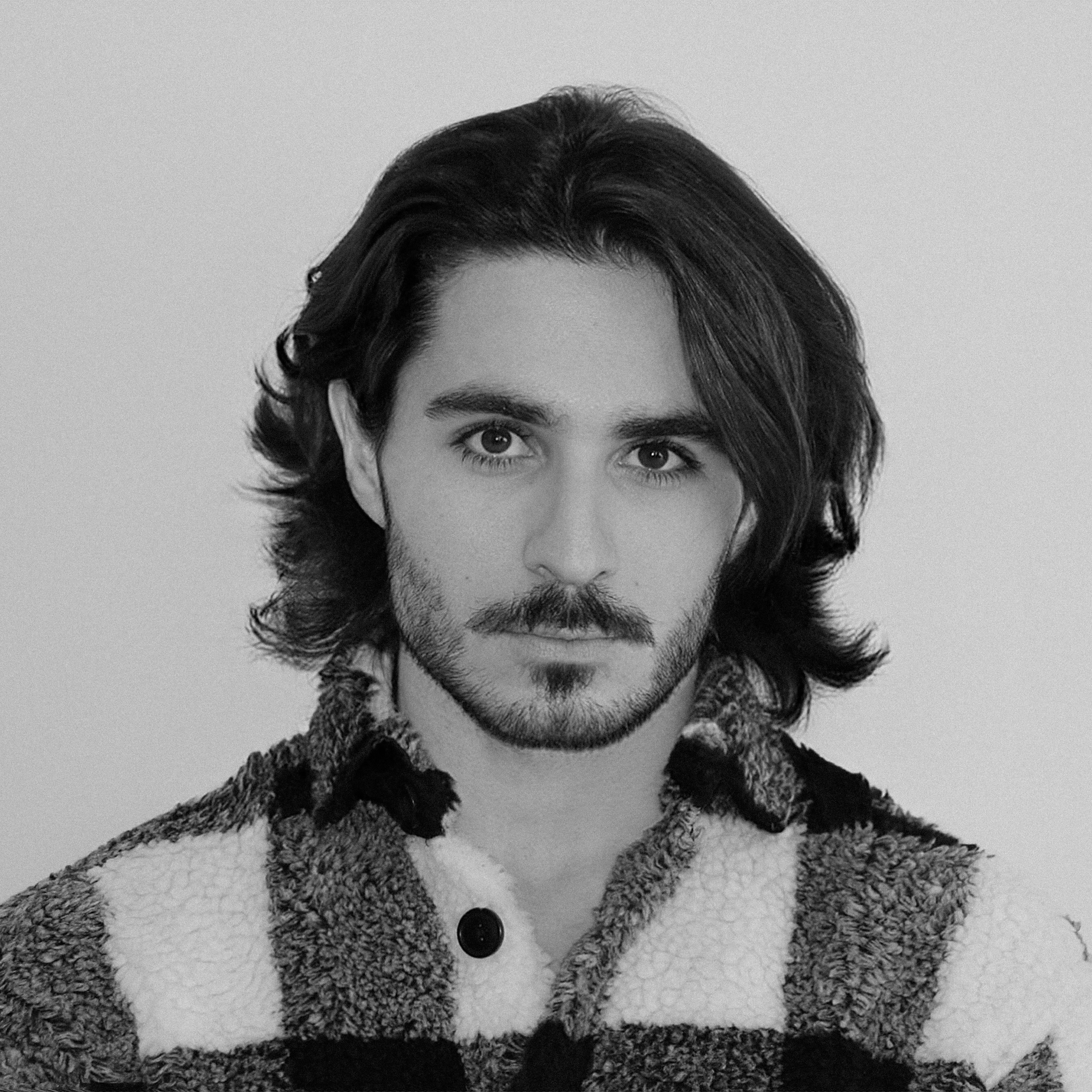 a black and white photo of a man with long hair