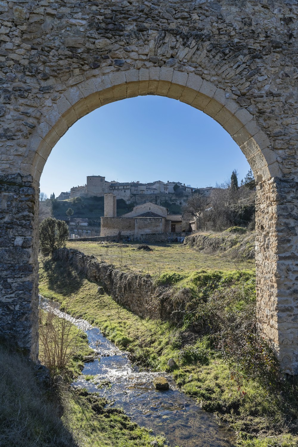 a small stream running under a stone bridge