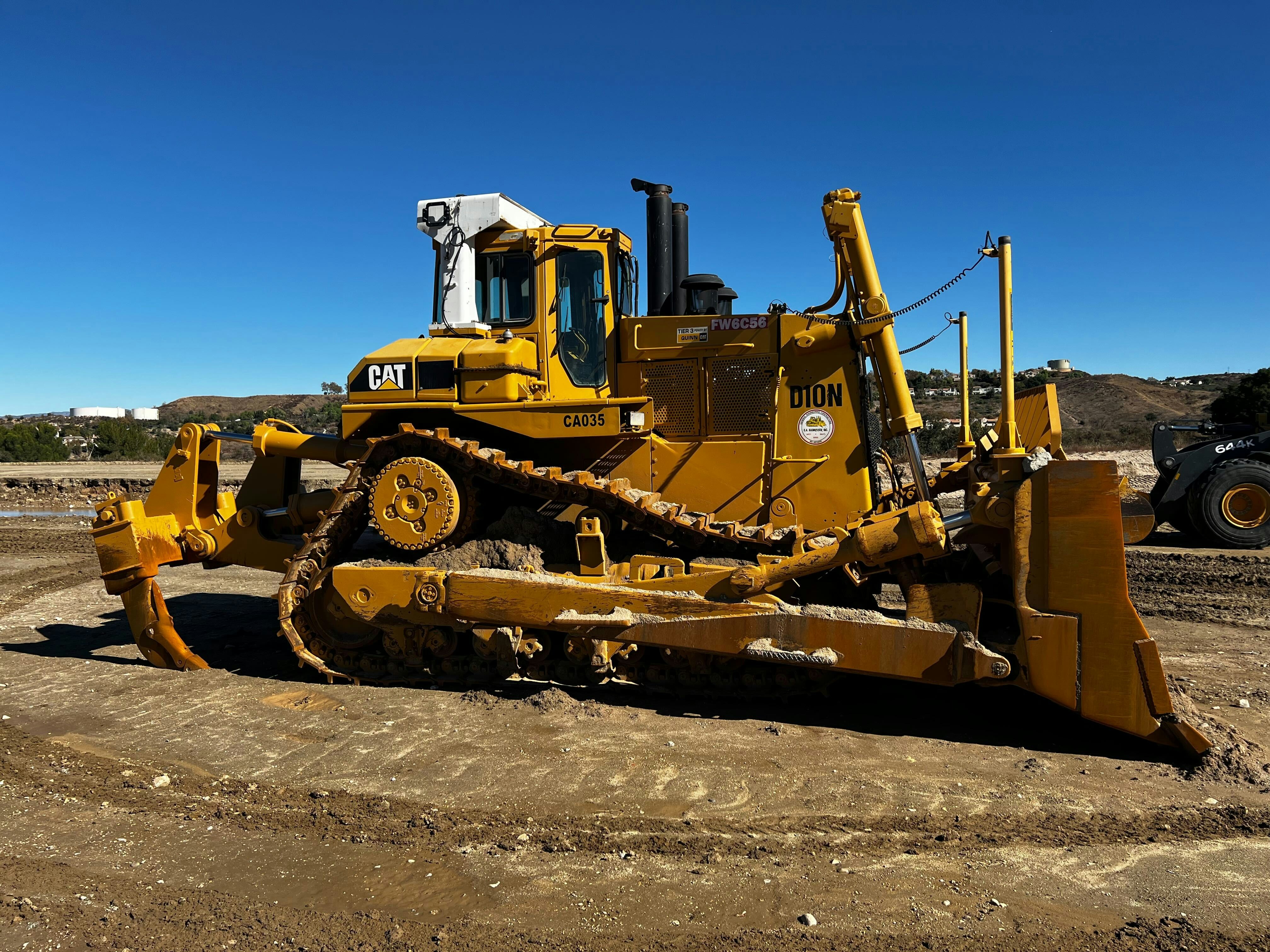 Large 120HP heavy duty tractor at a construction site, overcast industrial sky, massive steel machine