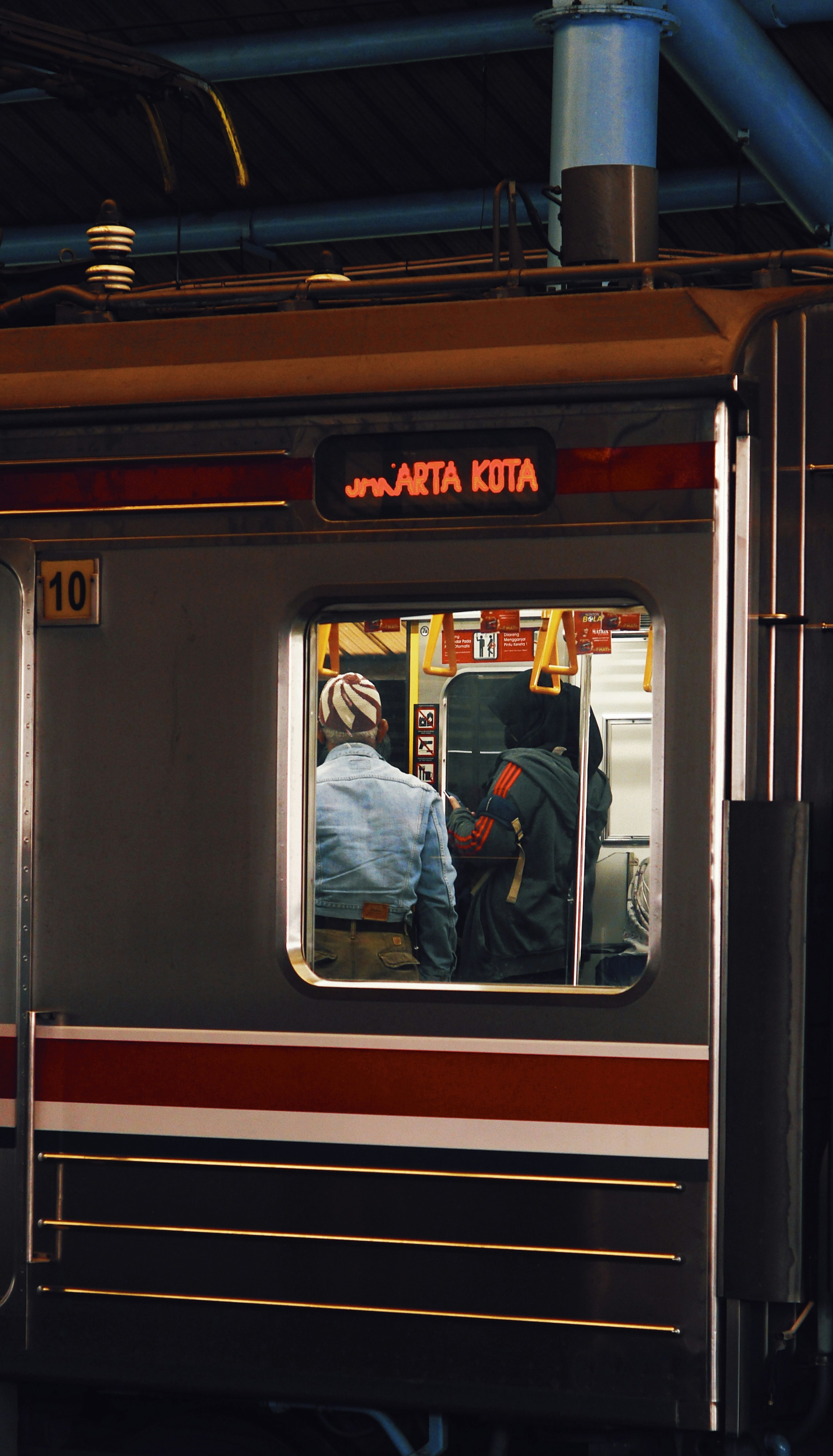 a train with a reflection of a man in the window