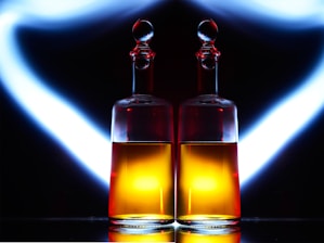 Elegant dark bottle of Sacáis licor de hinojo illuminated against a black velvet background