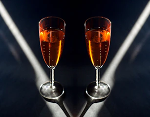 Elegant crowd in dark luxury setting, champagne glasses catching soft light without revealing faces.