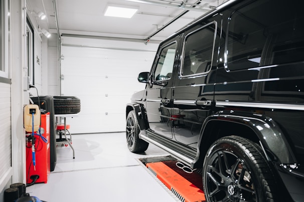 Family loading a car into a garage with a sturdy, well-maintained dark gray door.