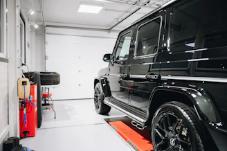 a black jeep is parked in a garage