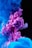 Vibrant plumes of pink and blue ink swirl and mix together in water, creating an abstract and mesmerizing pattern against a dark background.