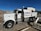 A large white industrial truck with "Calex Engineering Co." branding on the side is parked in an outdoor industrial setting. The truck has multiple axles and shiny metal tanks, indicating it may be used for specialized construction or engineering tasks. Additional buildings and equipment are visible in the background under a clear blue sky.