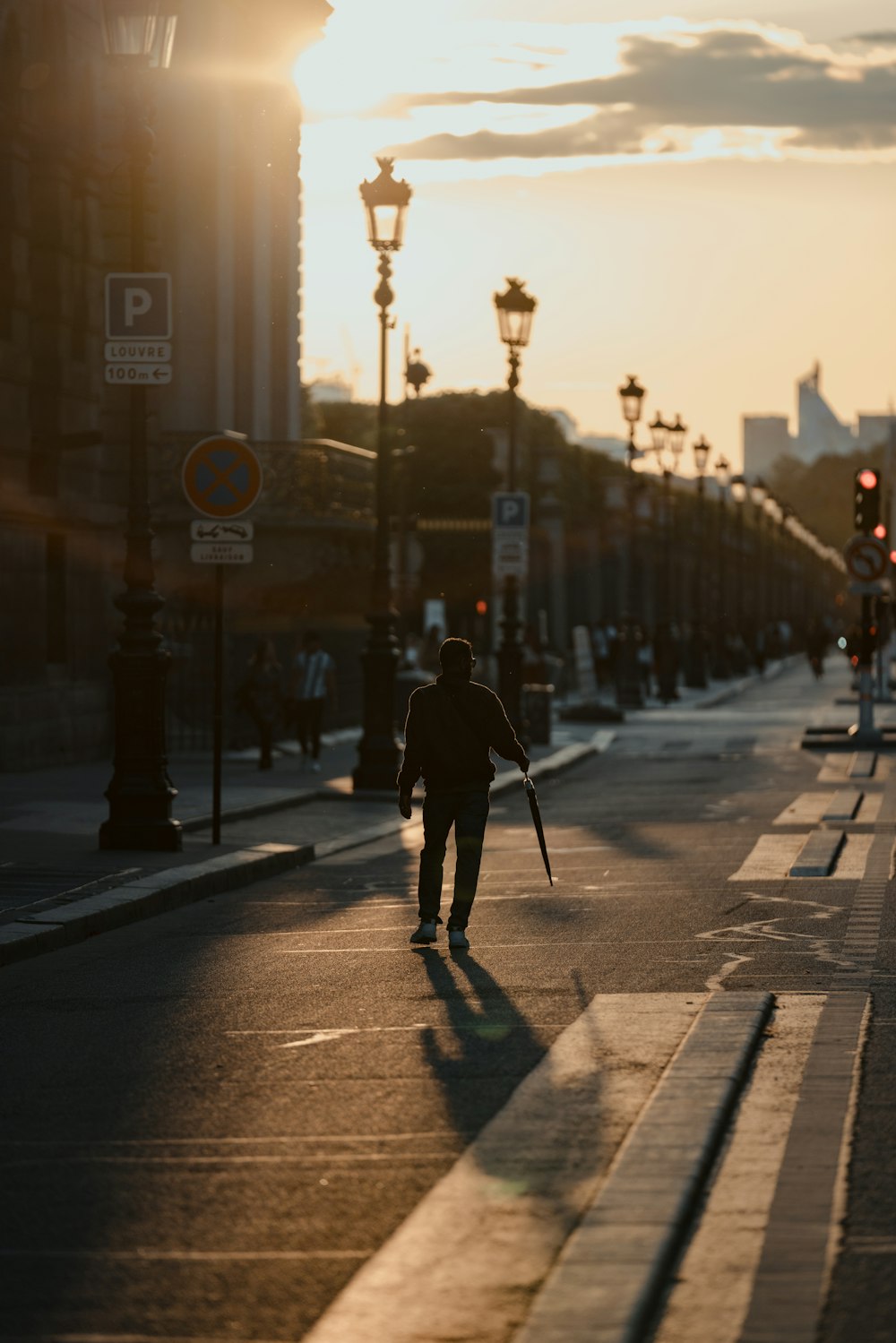 a man walking down a street holding a cane