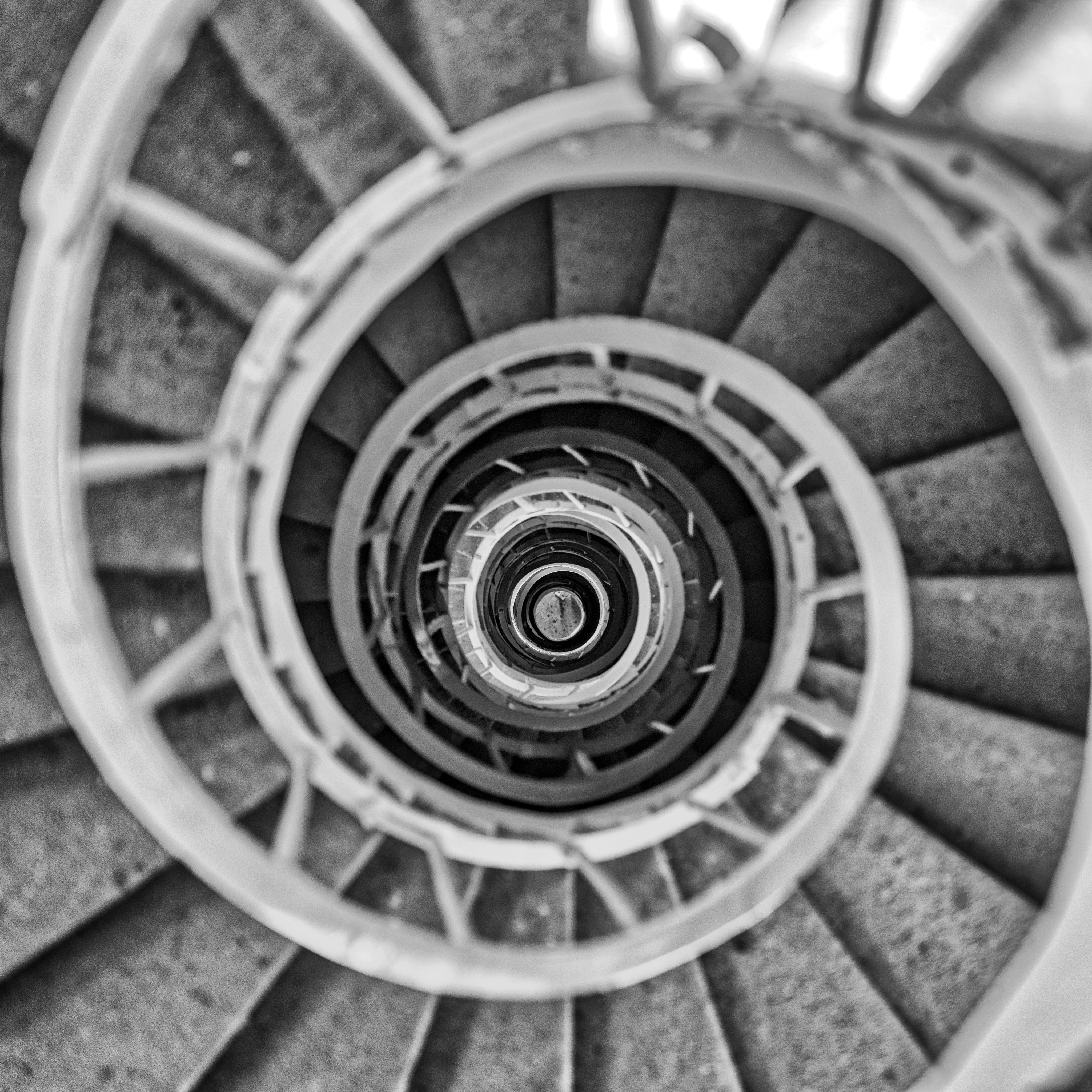 a black and white photo of a spiral staircase