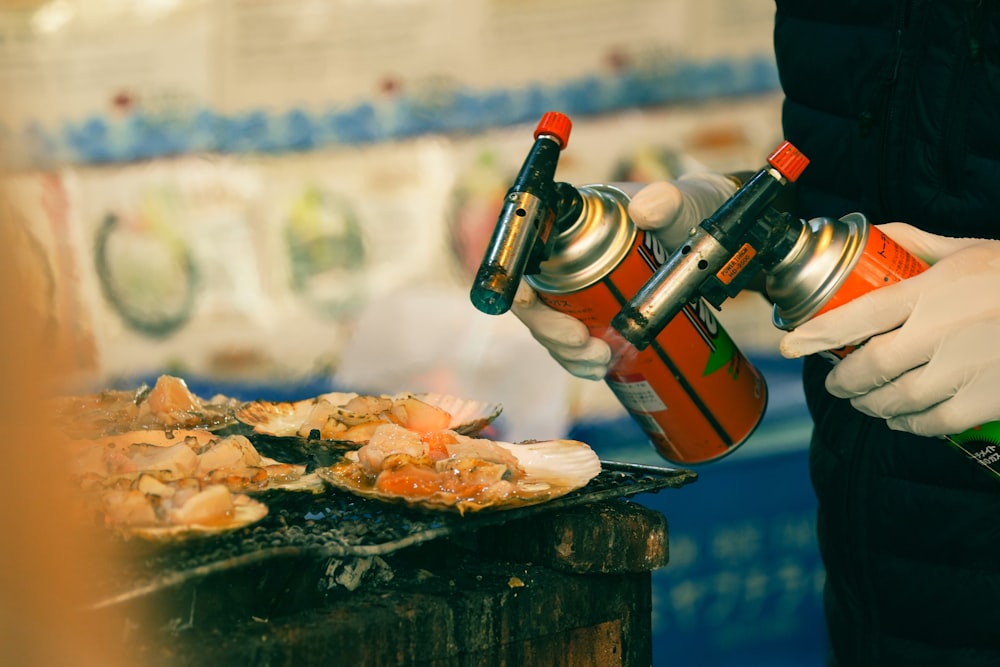 a person using a spray can to spray down food