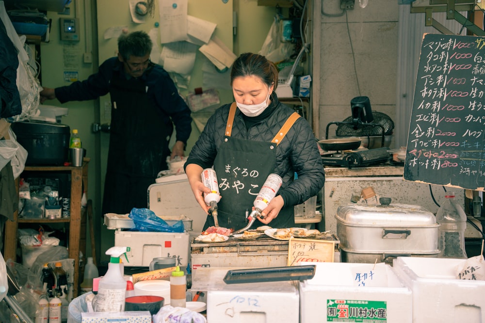 a woman wearing a face mask preparing food in a kitchen