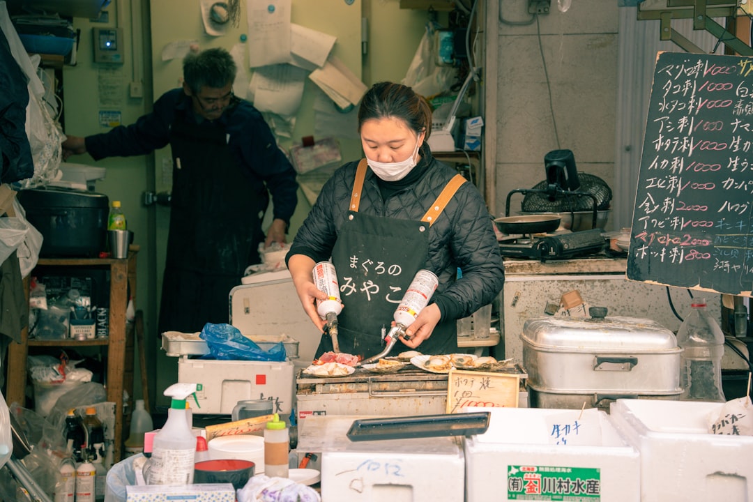 a woman wearing a face mask preparing food in a kitchen,