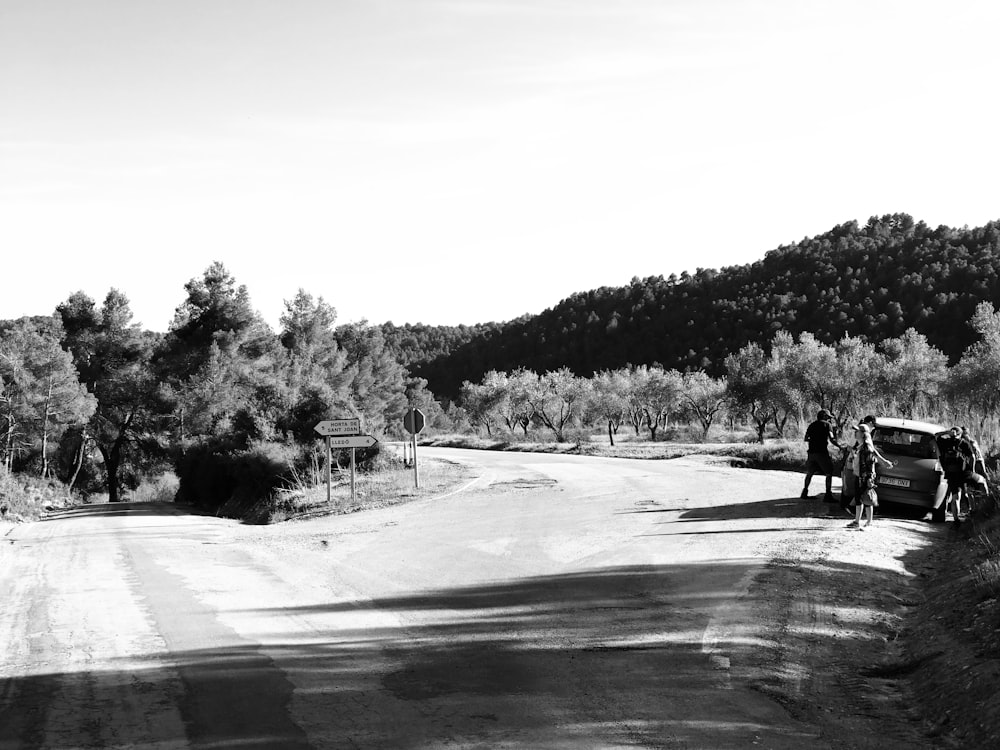 a group of people standing on the side of a road