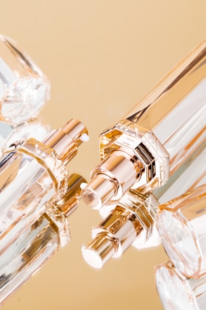 A close-up of elegant perfume bottles arranged on a wooden table with soft natural light.
