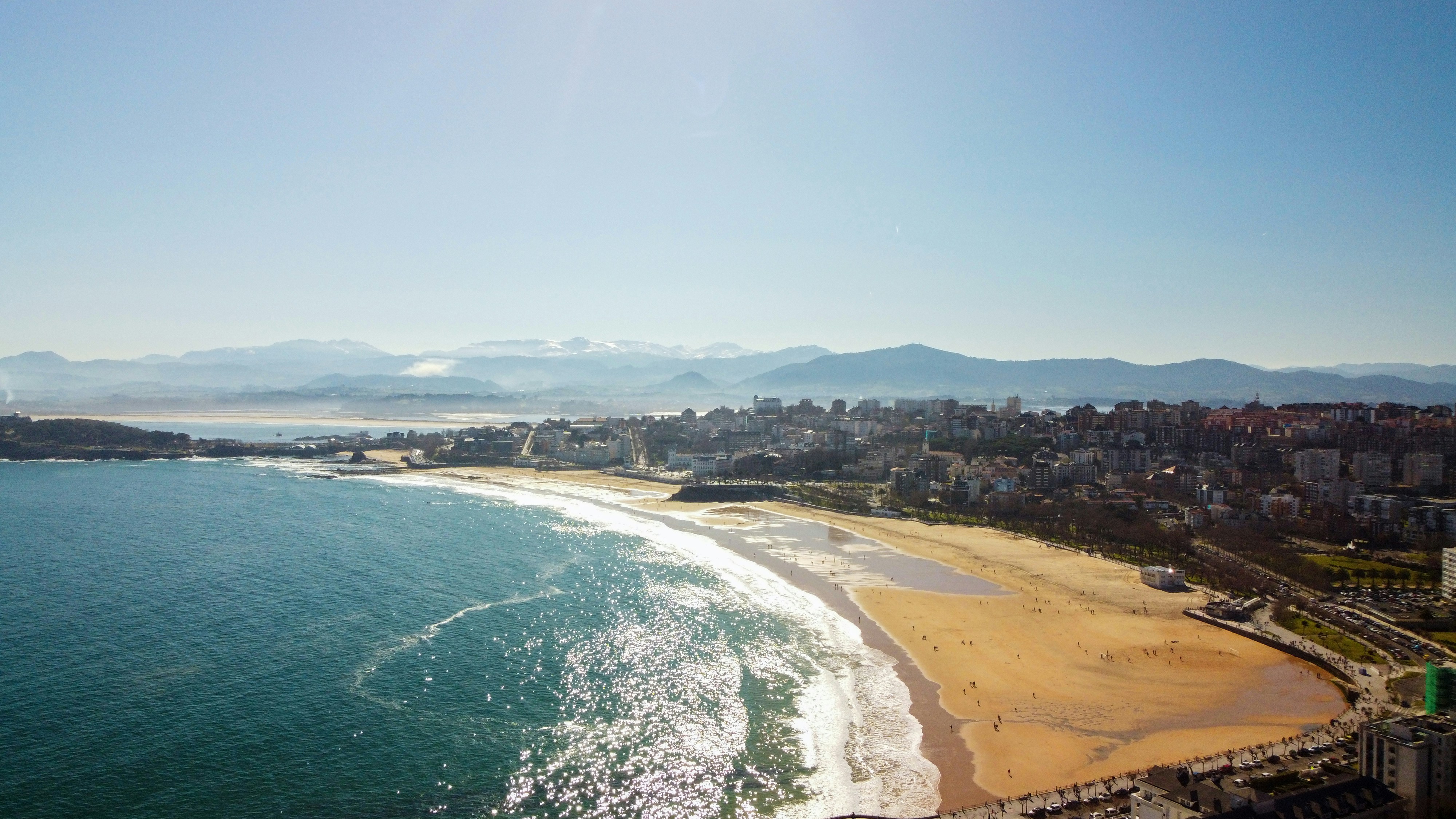 an aerial view of a beach with a city in the background