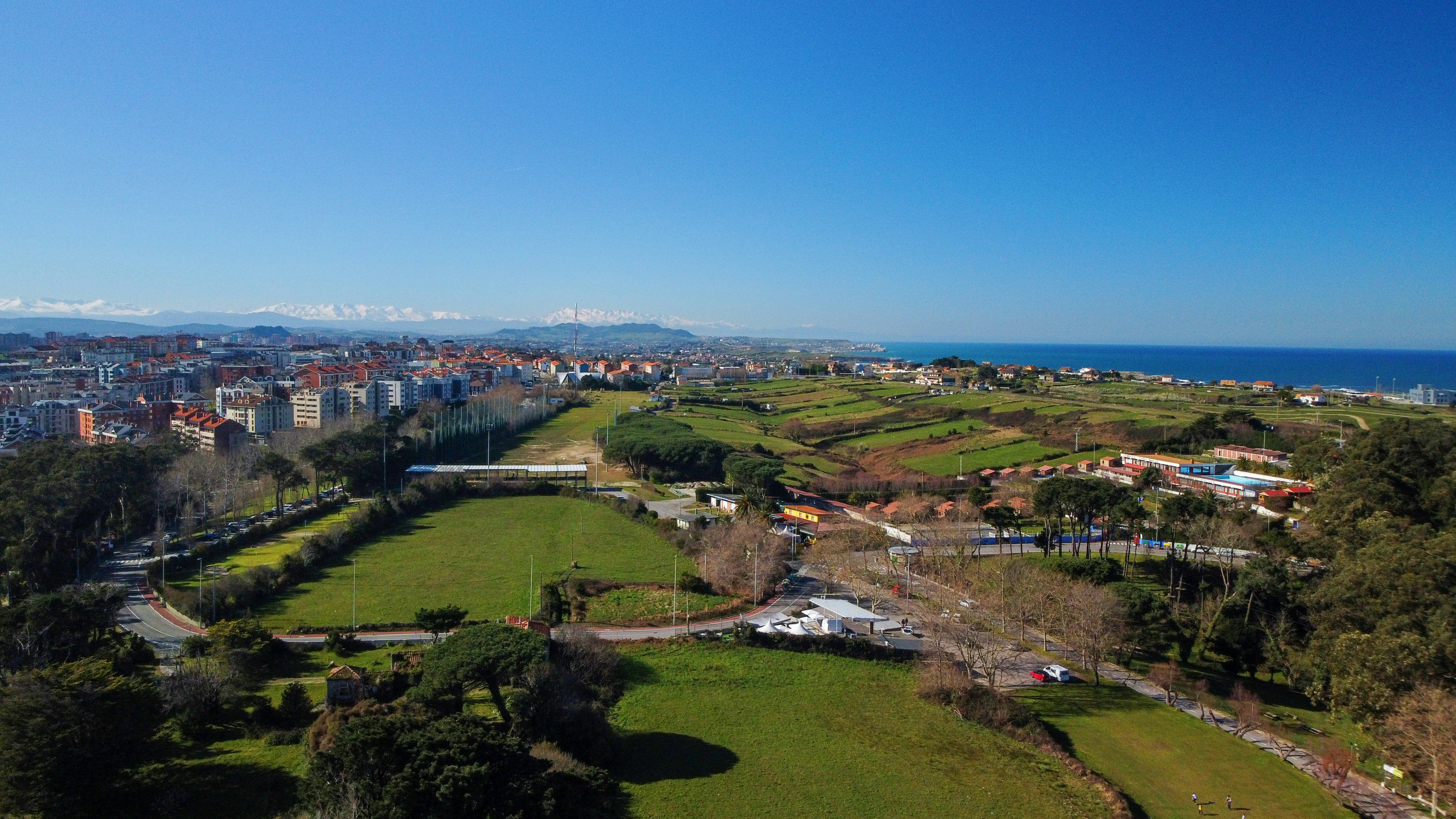 an aerial view of a green field and a city