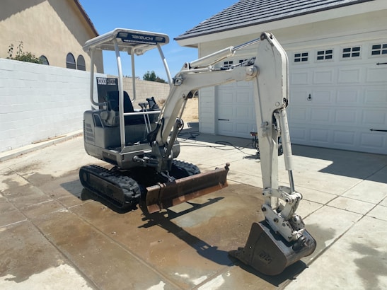Compact 1-2 ton mini excavator working on a residential construction site.