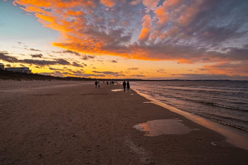 a group of people standing on top of a sandy beach