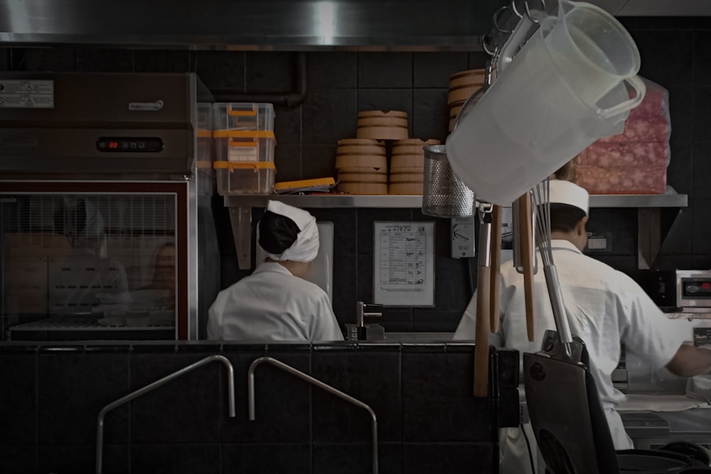 a couple of chefs working in a kitchen