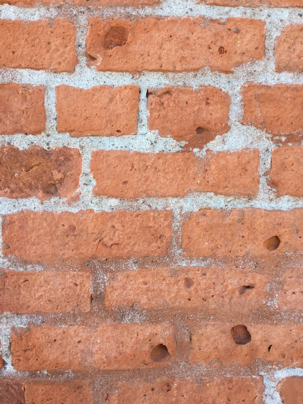 a close up of a brick wall with holes in it