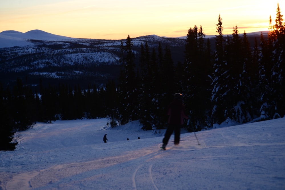 a person riding skis on top of a snow covered slope