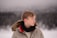 a young man standing in the snow wearing a jacket